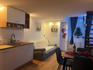 a kitchen and living room with a couch and a table at Apartman LA CASA 77B in Ljubljana