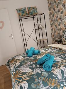 łóżko z niebieskimi ręcznikami na górze w obiekcie 29 Rue Mellaise, Appartement 3 pièces w mieście Niort