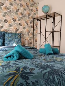 ein Bett mit blauen Decken und Kissen darauf in der Unterkunft 29 Rue Mellaise, Appartement 3 pièces in Niort