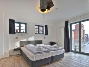 a bedroom with a bed and a large window at Ohlerich Speicher App_ 08 in Wismar