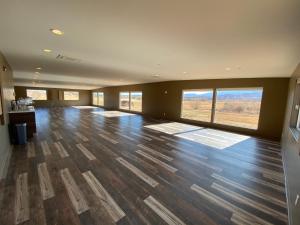 a large empty room with wooden floors and large windows at Red Sands Hotel in Torrey