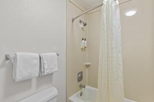 モアヘッドシティにあるGarnet Inn & Suites, Morehead City near Atlantic Beachの白いバスルーム(シャワー、トイレ付)