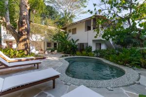 a swimming pool in the middle of a garden at Hotel Vila São João in Trancoso