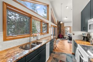 eine Küche mit einem Waschbecken und zwei Fenstern in der Unterkunft Mill Creek Cabin - Dumont in Dumont