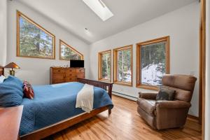 um quarto com uma cama, uma cadeira e janelas em Mill Creek Cabin - Dumont em Dumont