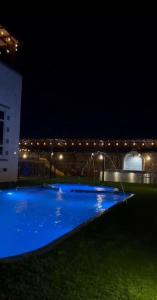a swimming pool lit up at night at Bait Alsalam in Sayq