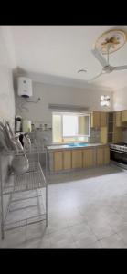 a large kitchen with a white tile floor at Bait Alsalam in Sayq