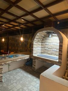 a kitchen with a pizza oven in a room at Bait Alsalam in Sayq