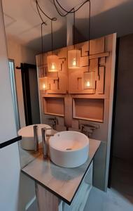 a bathroom with two sinks on a counter with lights at okeyloft Coyhaique 1 in Coihaique
