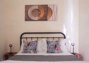 um quarto com uma cama com duas almofadas e uma fotografia em Holiday Home Panglao Island em Dauis
