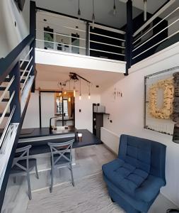 eine Küche und ein Wohnzimmer mit einem blauen Stuhl und einer Treppe in der Unterkunft Okeyloft, Coyhaique 2 in Coihaique