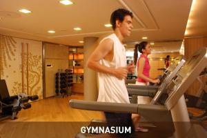 a man and a woman running on a treadmill in a gym at Impiana KLCC Hotel in Kuala Lumpur
