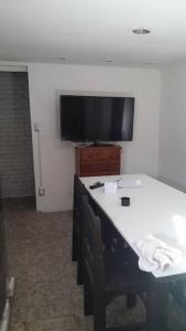 Habitación con TV en la pared y mesa. en Casa Familiar 6 per con Vista Se RESERVA Con SEÑA UTE APARTE, en San Luis