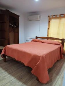 Un dormitorio con una cama con una manta roja. en Casa Familiar 6 per con Vista Se RESERVA Con SEÑA UTE APARTE, en San Luis