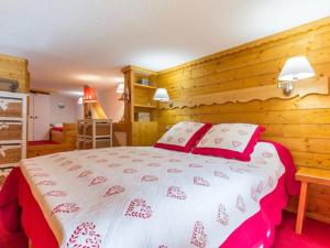 a bedroom with a bed with red and white sheets and pillows at Appartement Les Arcs 1800, 2 pièces, 6 personnes - FR-1-346-412 in Arc 1800