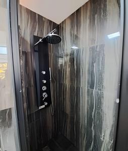 a shower in a bathroom with a black wall at Okeyloft Coyhaique 4 in Coihaique