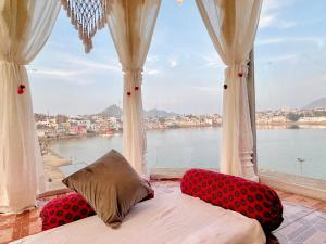 Dormitorio con ventana grande con vistas al agua en Hotel Kota kunj Heritage en Pushkar