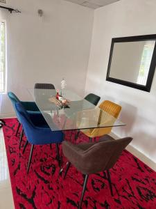 a dining room with a glass table and chairs at Four m luxury Apartment. in Kitwe