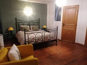 een slaapkamer met een bed en een bank in een kamer bij La Libellule in Couvin