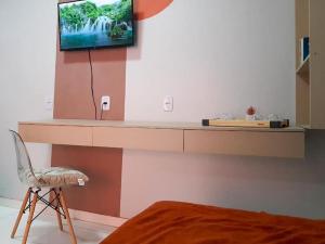 um quarto com uma televisão numa parede com uma cadeira em Apto com Varanda Próximo da Orla em Marabá