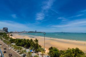 a view of a beach with palm trees and the ocean at Baboona Beachfront Living in Pattaya Central