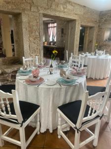 una mesa con mantel blanco y 2 sillas en Casa A Canteira, en Vimianzo