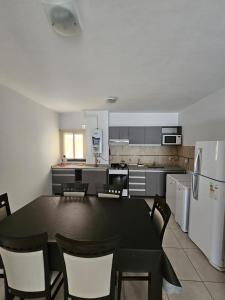 a kitchen with a table and chairs and a refrigerator at Apartamento Esquiu C in Villa Carlos Paz