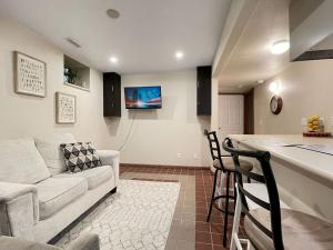 a kitchen and a living room with a couch and a bar at Chic 2br - 2 Min From Icubs in Des Moines