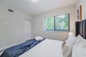 biała sypialnia z łóżkiem i oknem w obiekcie Apartment in Calle Ocho a Slice of Little Havana w Miami