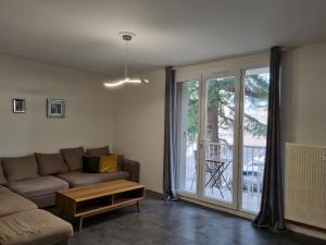 uma sala de estar com um sofá e uma grande janela em Cathédrale, champagne near, park and stores close em Reims