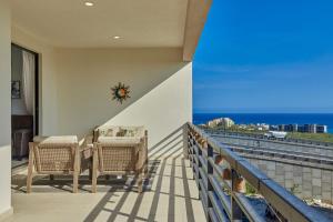 uma varanda com cadeiras e uma mesa e o oceano em Casa El Ocaso em Cabo San Lucas
