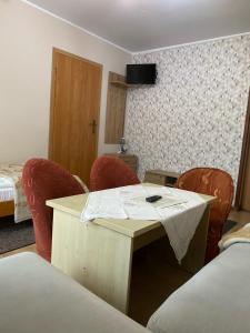 a room with red chairs and a table and a bed at Willa Potoki in Szklarska Poręba