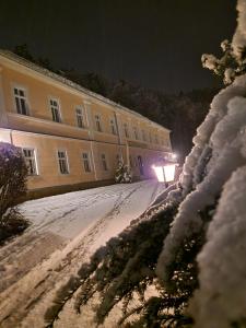 ein Gebäude in der Nacht mit Schnee auf dem Boden in der Unterkunft Hotel Garni Dekorahaus in Bad Schandau
