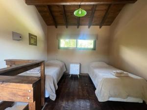 1 dormitorio con 2 camas en una habitación con ventana en Cabañas Los 4 elementos - Uspallata en Las Heras