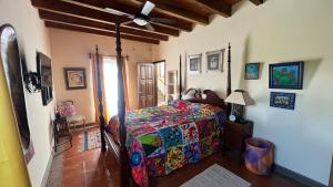 sypialnia z łóżkiem z kolorową kołdrą w obiekcie casa la vida es buena w mieście San Miguel de Allende