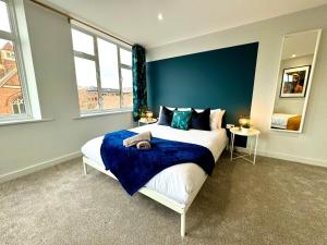1 dormitorio con 1 cama grande y pared azul en Incredible Large 3 Bedroom Apartment - Sleeps 8!, en Bournemouth