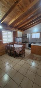 uma cozinha com mesa e cadeiras num quarto em Cabaña Amapola, Pichidangui em Pichidangui