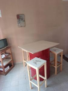 a kitchen with a table and two stools and a counter at Posada de la Costa in Villa Carlos Paz