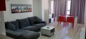 uma sala de estar com um sofá e uma mesa com cadeiras vermelhas em ALOJAMIENTO EN EL CASCO HISTÓRICO DE CARTAGENA em Cartagena