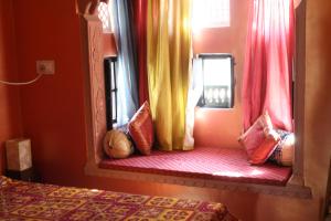 um quarto com uma cama e uma janela com cortinas em Bundi Inn - A Heritage Boutique Haveli em Bundi