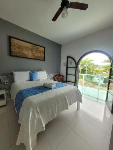 una camera da letto con un letto e un ventilatore a soffitto di Casa da Edna a Guarujá Altre 38 foto