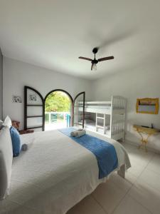 a bedroom with a large bed with a ceiling fan at Casa da Edna in Guarujá