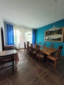 Casa da Edna في غوارويا: غرفة طعام مع طاولة وكراسي خشبية