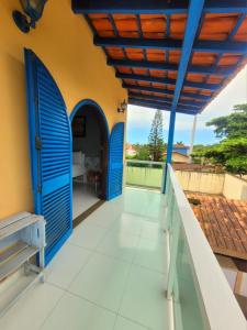 una casa con porte blu e balcone di Casa da Edna a Guarujá