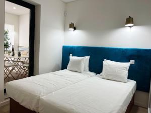 a bedroom with a blue headboard and two white pillows at Boutique Style Town House in Albufeira