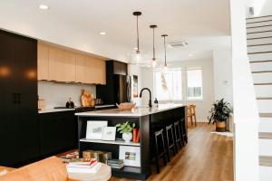 una cocina con armarios negros y una isla de cocina en New Downtown Hailey Condo with Rooftop Hot Tub, en Hailey