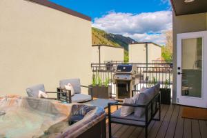 a patio with chairs and a grill on a deck at New Downtown Hailey Condo with Rooftop Hot Tub in Hailey
