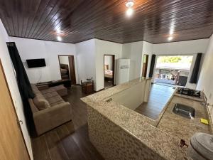 cocina y sala de estar con sofá y encimera en Diniz Chacara, en Guaratinguetá