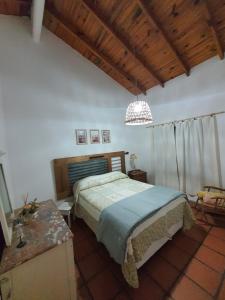 a bedroom with a bed and a wooden ceiling at Casa Colibrí in San Carlos de Bolívar