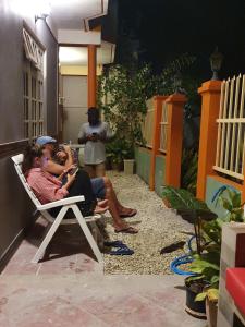 Thimarafushi的住宿－Mikado Surf Camp，一群人坐在庭院的椅子上